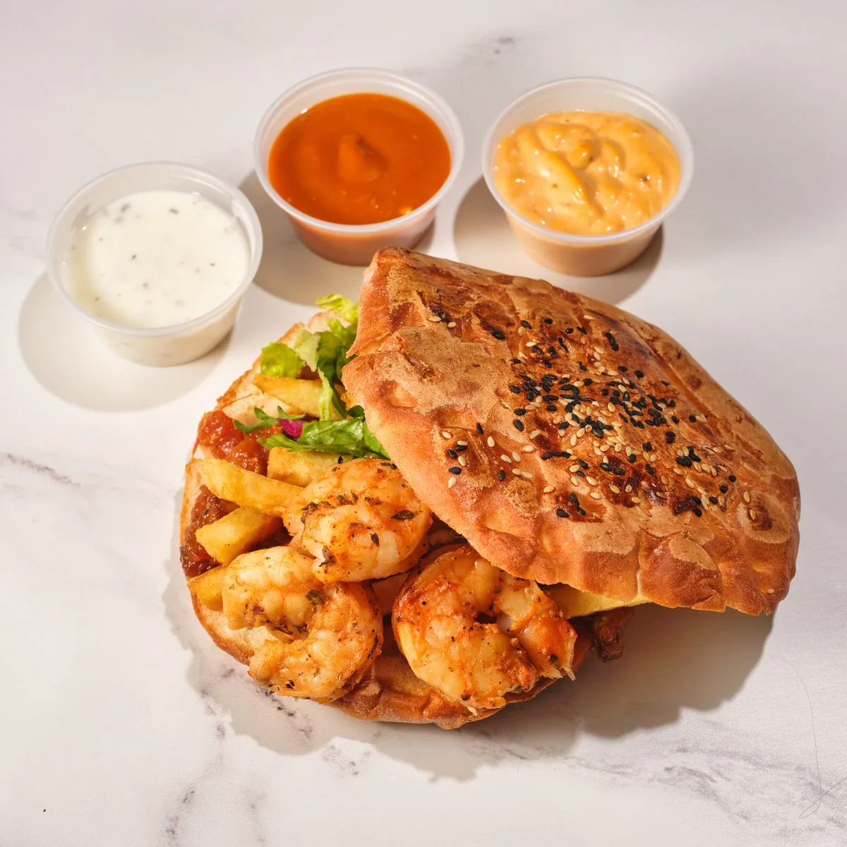 Loaded shrimp po'boy served with fries and dipping sauces